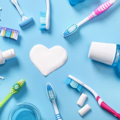 A collection of dental tools around a heart shape made of toothpaste